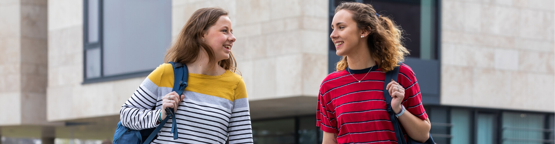 Two UCD students walking and laughing.